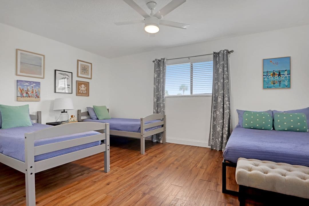 Kids room with four beds and coastal artwork